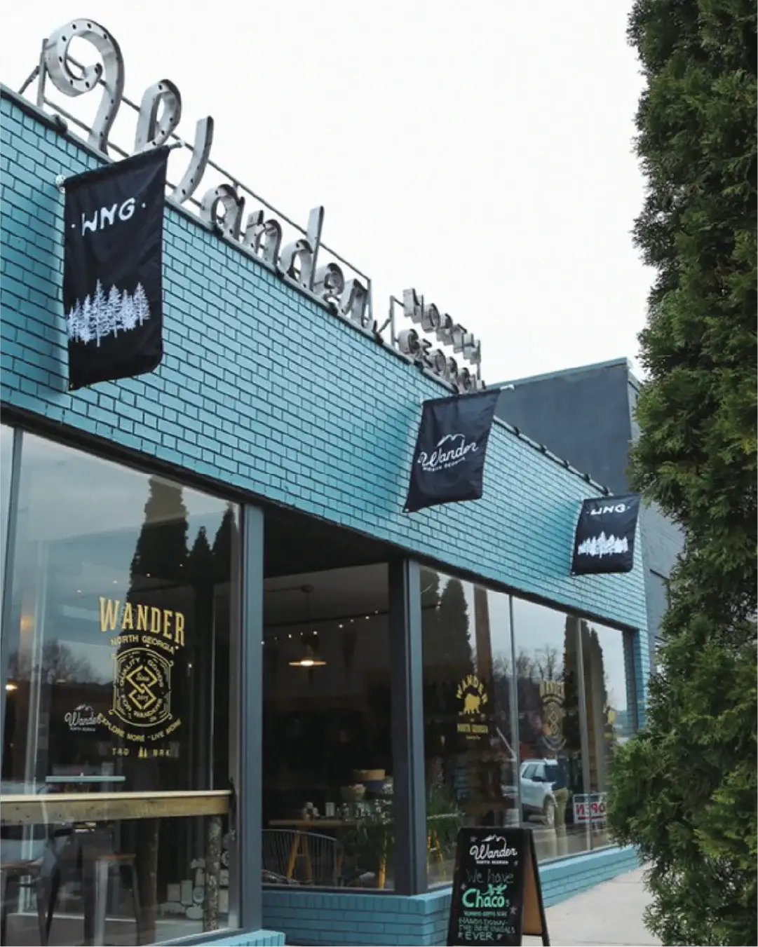 Blue brick building with 'Wander' branding and glass windows.