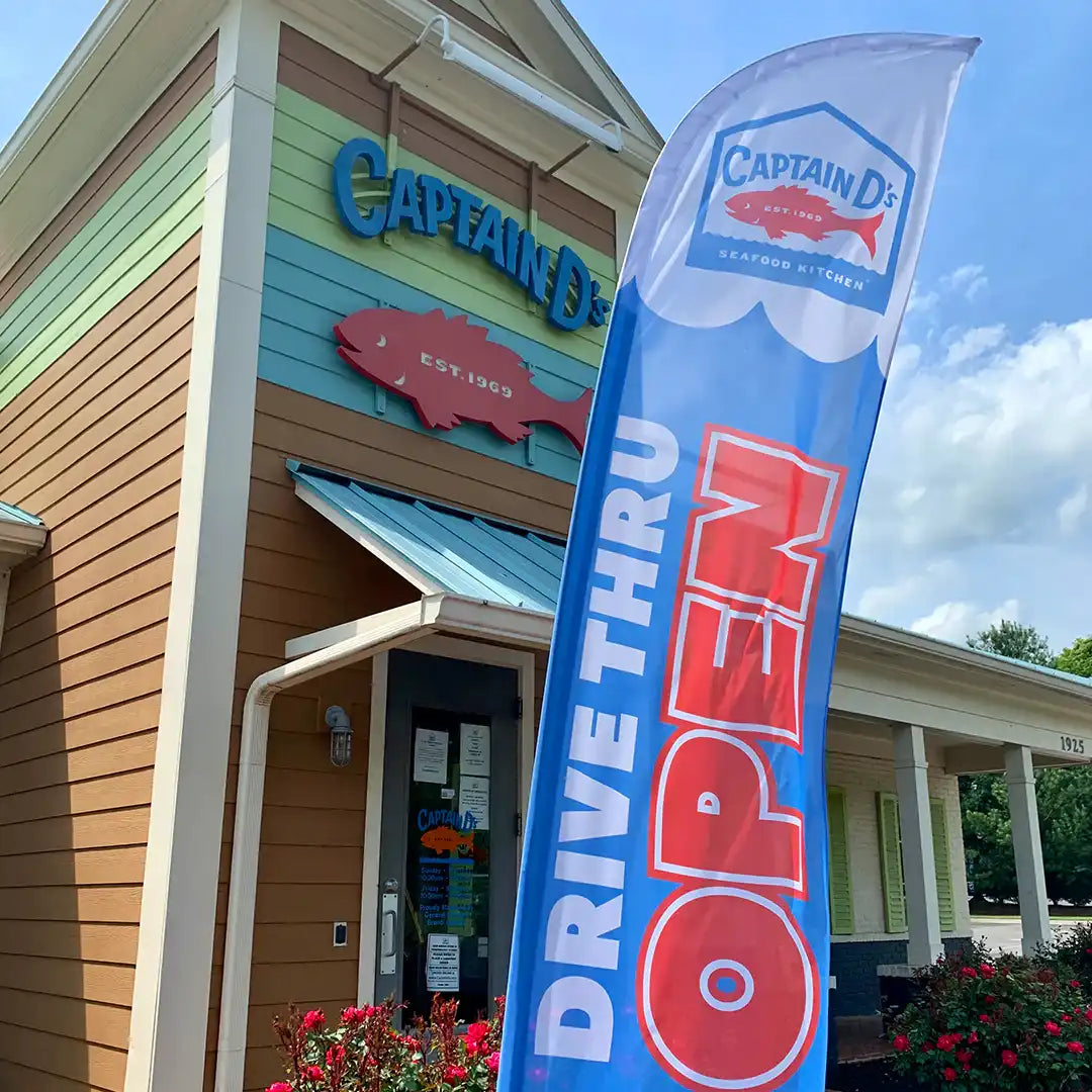Captain D's restaurant exterior with a large 'Drive Thru Open' flag.