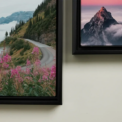 Two framed pictures of mountain landscapes on a wall.