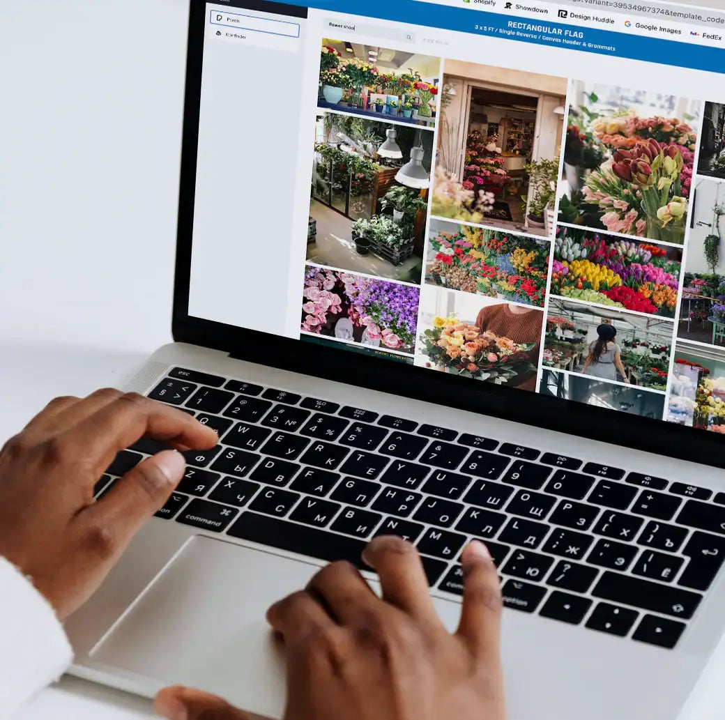 Person using a laptop with a floral design website open on the screen.